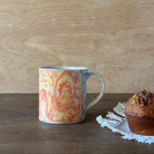 Load image into Gallery viewer, Mug with colorful design next to a muffin on a wooden surface