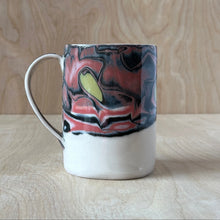 Load image into Gallery viewer, Ceramic mug with red, black and chartruese abstract design on a wooden surface
