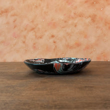 Load image into Gallery viewer, shallow black ceramic bowl with red and turquoise  patterns on a wooden surface
