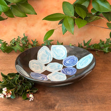 Load image into Gallery viewer, Decorative bowl with blue and white abstract designs on a wooden surface with greenery.
