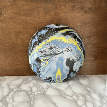 Load image into Gallery viewer, Bottom side of ceramic bowl with blue, yellow, and black pattern on a marble surface with wooden background
