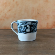 Load image into Gallery viewer, White mug with black and gray abstract design on a wooden surface
