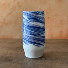 Load image into Gallery viewer, Cylindrical ceramic vase with blue and white marbled pattern on a wooden surface.
