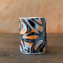Load image into Gallery viewer, Marbled ceramic mug with black, orange, and gray design on a wooden surface.
