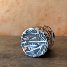 Load image into Gallery viewer, Marbled cup bottom on a wooden surface with a wooden background
