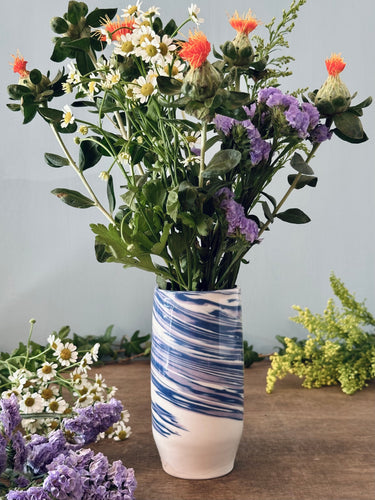 Vase with floral arrangement on a wooden surface