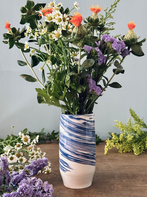 Vase with floral arrangement on a wooden surface