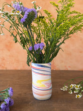 Load image into Gallery viewer, Striped red, blue, and yellow porcelain vase with flowers on a wooden surface
