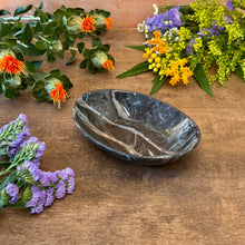 Load image into Gallery viewer, Black marbled ceramic dish on a wooden surface with flowers around it
