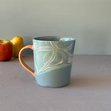 Load image into Gallery viewer, Blue ceramic mug with a water pattern on a gray surface with apples in the background

