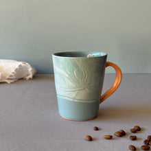 Load image into Gallery viewer, Blue ceramic mug with water design on a neutral background
