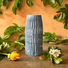 Load image into Gallery viewer, Blue textured vase on a wooden surface with green leaves and flowers
